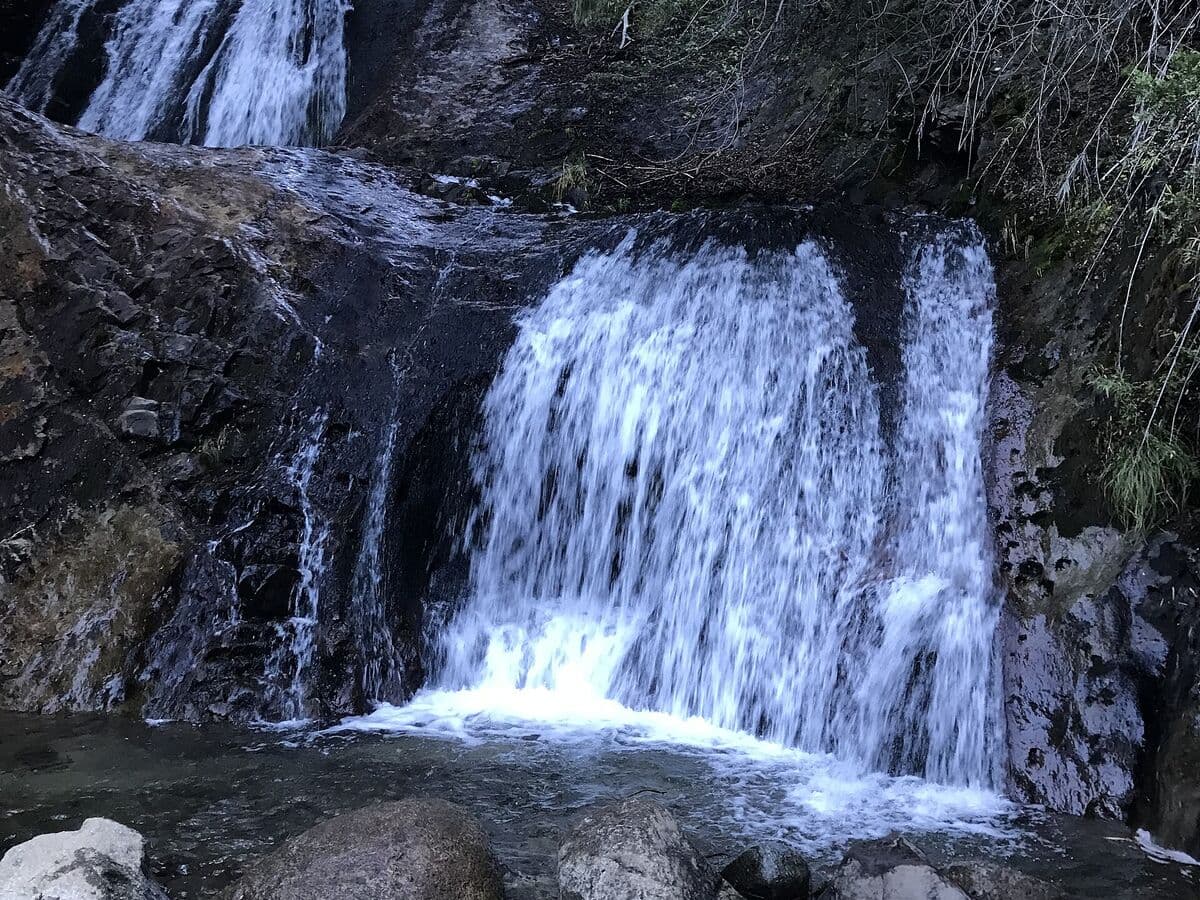 La Cascada de los Duendes cayendo sobre la roca, en el bosque de Villa Los Coihues